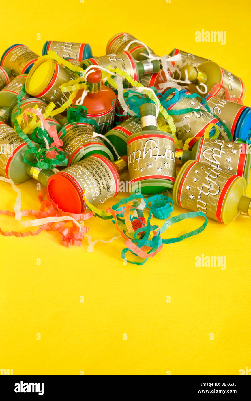 A pile of party poppers on yellow background with space for copy Stock Photo