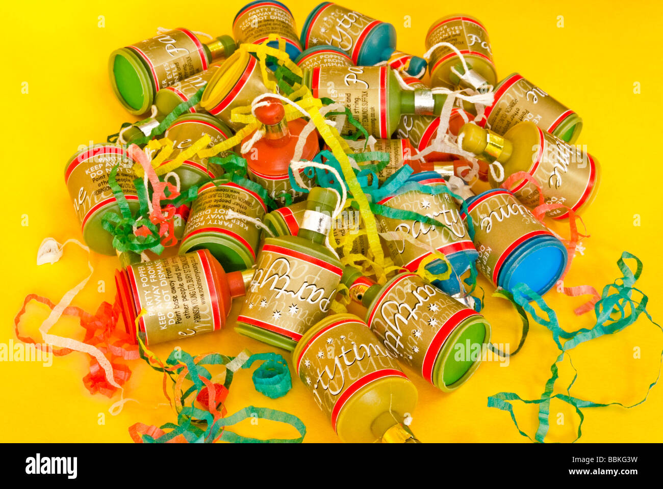 Party poppers on a plain yellow background Stock Photo