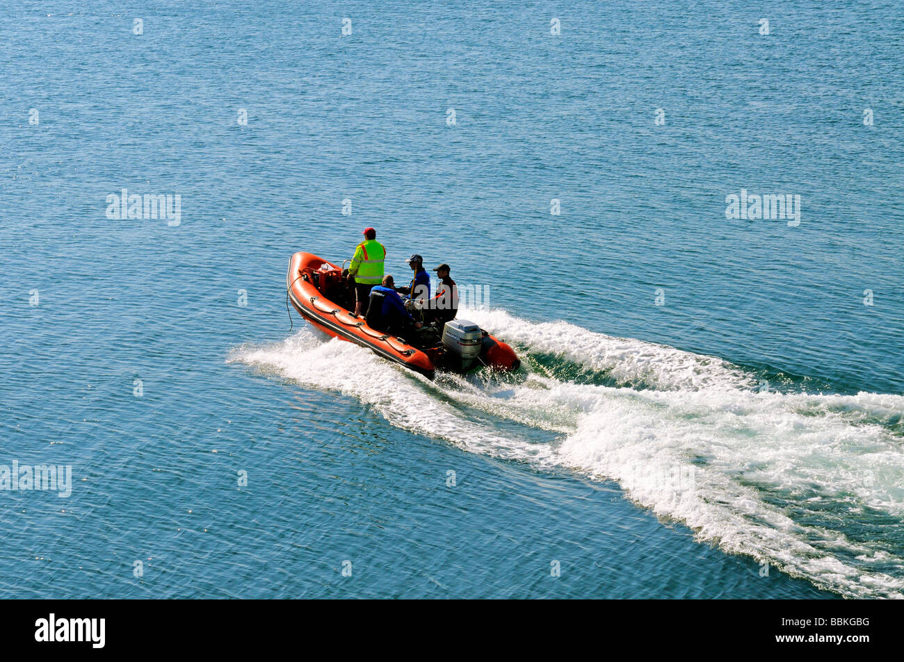 Orange RIB Ridged Inflatable Boat boat with wake crossing the sea Stock Photo