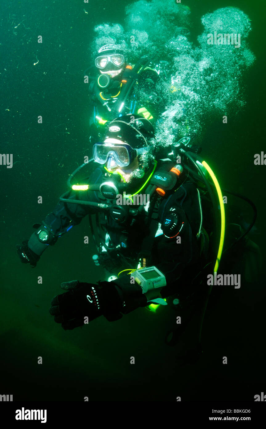 Two scuba divers on underwater wreck of ship the HMS Scylla Plymouth Devon UK Stock Photo