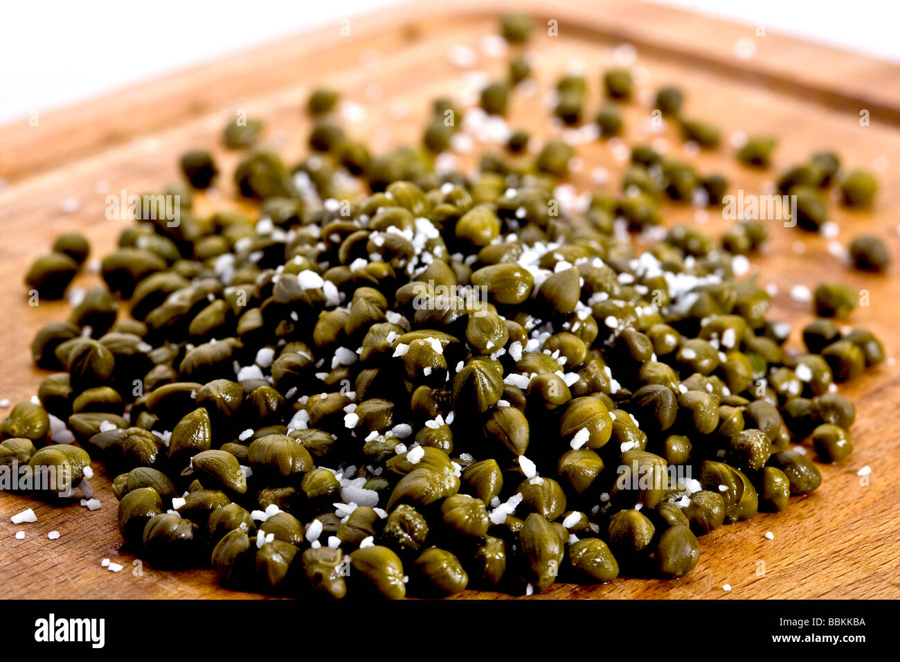 Capers on carving board Stock Photo