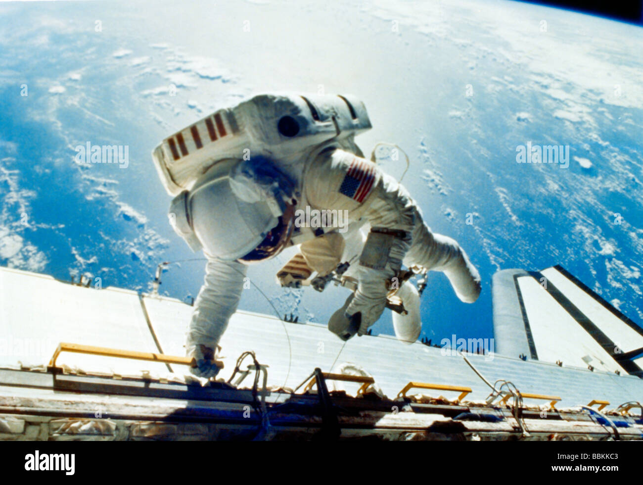 Astronaut Dale Gardner Tethered to Space Shuttle Discovery Starboard Side wearing a Manned Maneuvering Unit (MMU) during Extravehicular Activities (EV Stock Photo