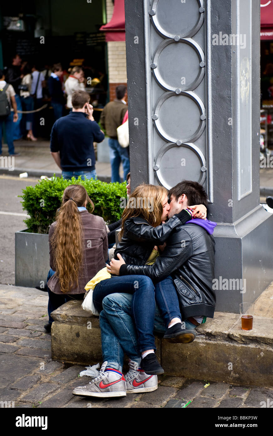 Two young people kissing at Borough Market in London. Stock Photo