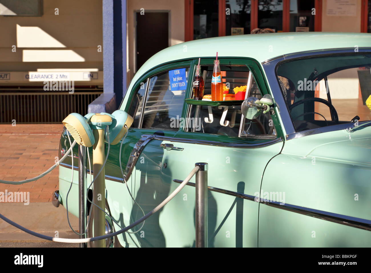 Vintage car with fifties drive in speakers and tray of food Stock Photo