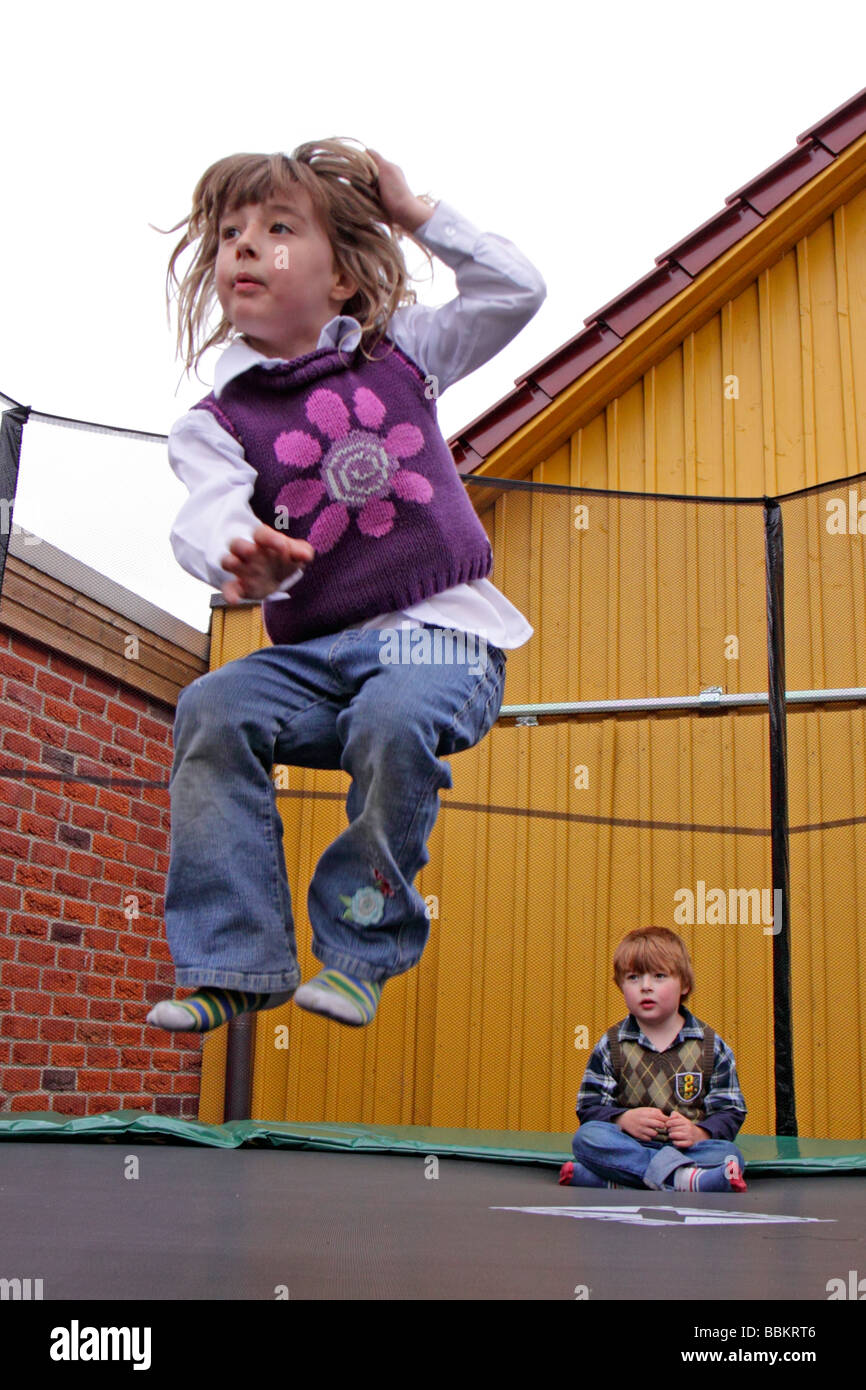 young children jumping on a trampoline Stock Photo