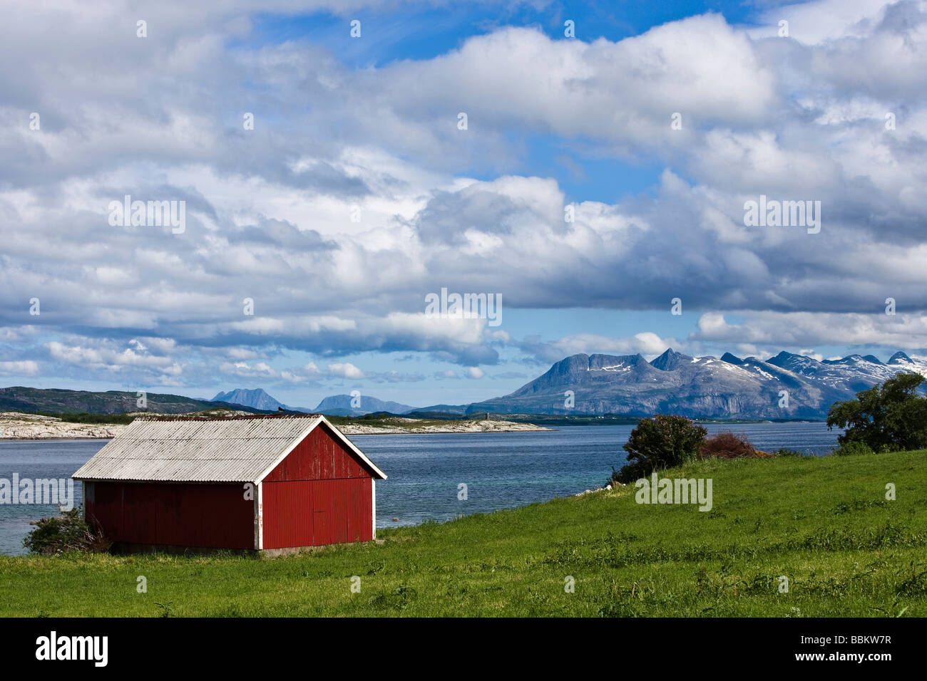 Red wooden shed and Seven Sisters mountain range Kystriksveien Nordland