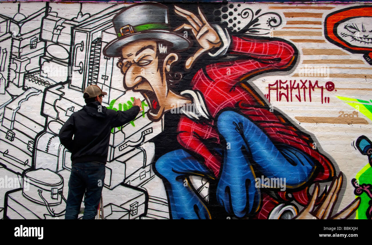graffiti artist working on design in Bacon Street Shoreditch London UK Stock Photo