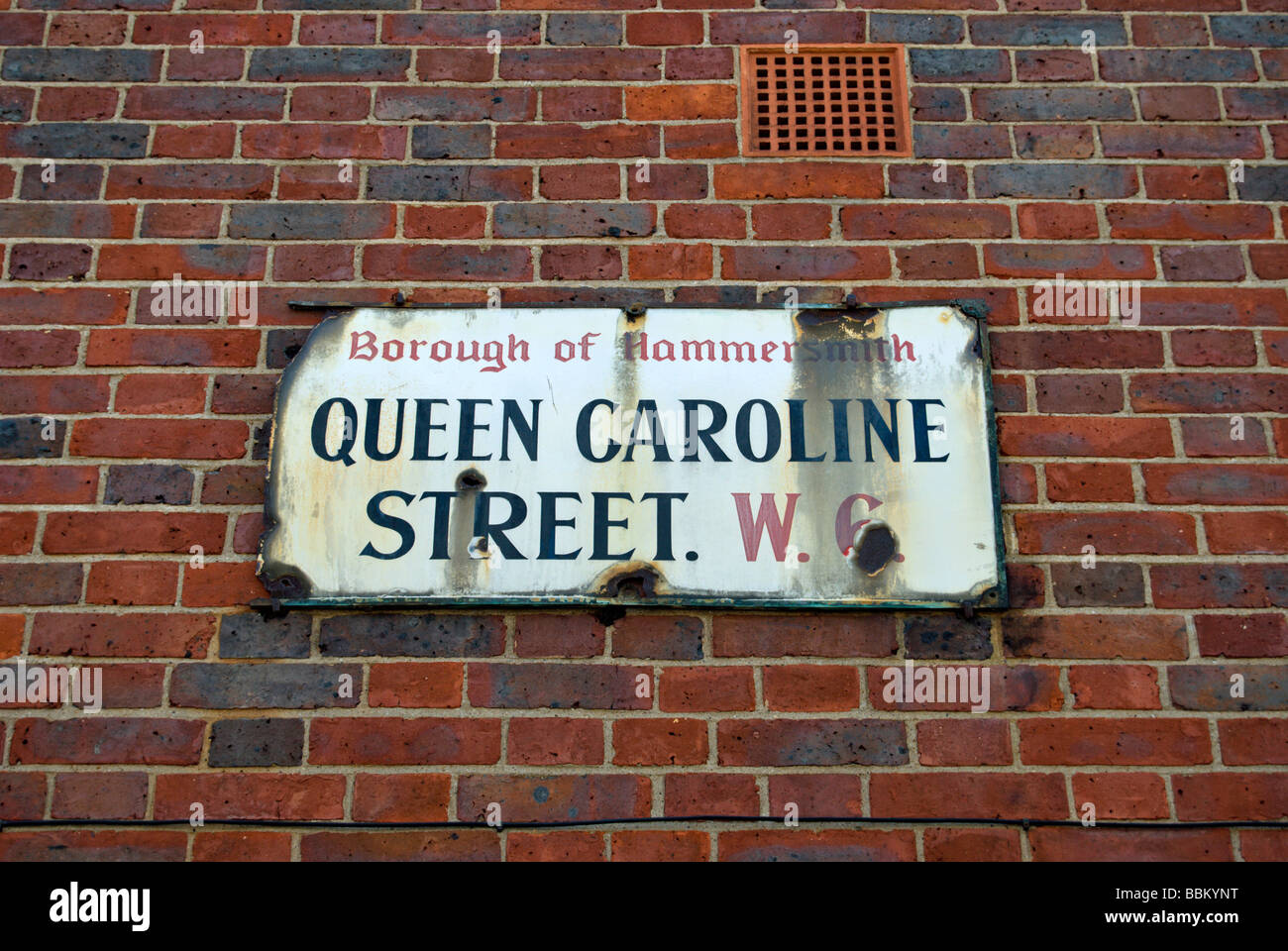 dilapidated street name sign for queen caoline street, hammersmith, west london, england Stock Photo