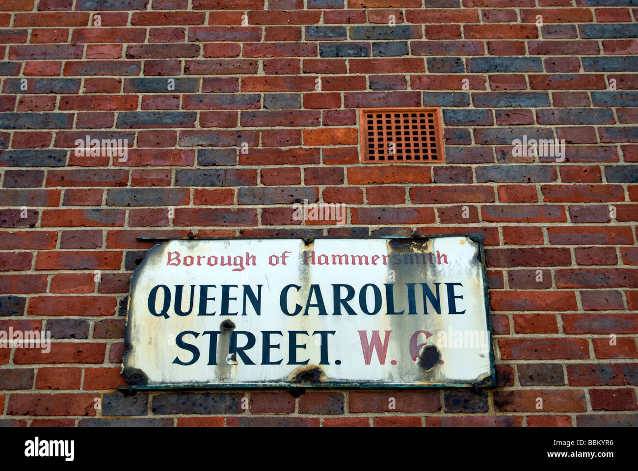 dilapidated street name sign for queen caoline street, hammersmith, west london, england Stock Photo
