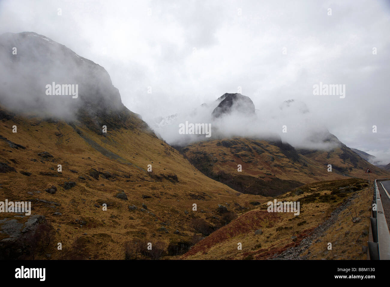Mist lapping around theSisters of Glencoe, Scottish Highlands Stock Photo