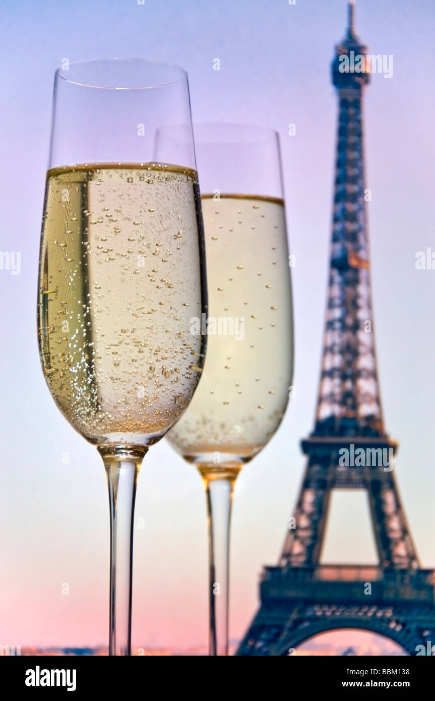 CHAMPAGNE EIFFEL TOWER PARIS ROMANTIC SUNSET Two glasses of sparkling champagne with the Eiffel Tower at sunset behind. Paris France Stock Photo