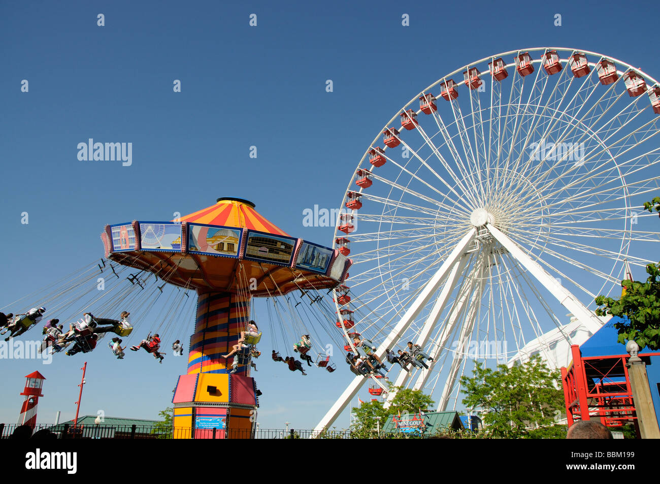 Funfair rides Ferris Wheel and the Wave Swinger on Navy Pier Chicago Illinois USA f Stock Photo