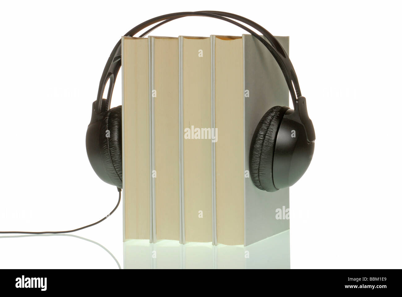 Headphones on four books, symbolic for audiobooks Stock Photo