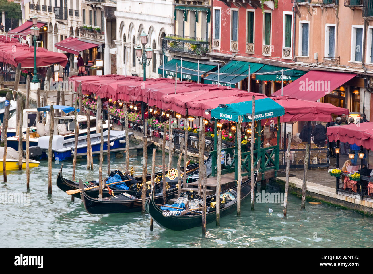 Restaurant seating and gondola moorings on the Grand Canal Riva del Vin Venice Italy Stock Photo