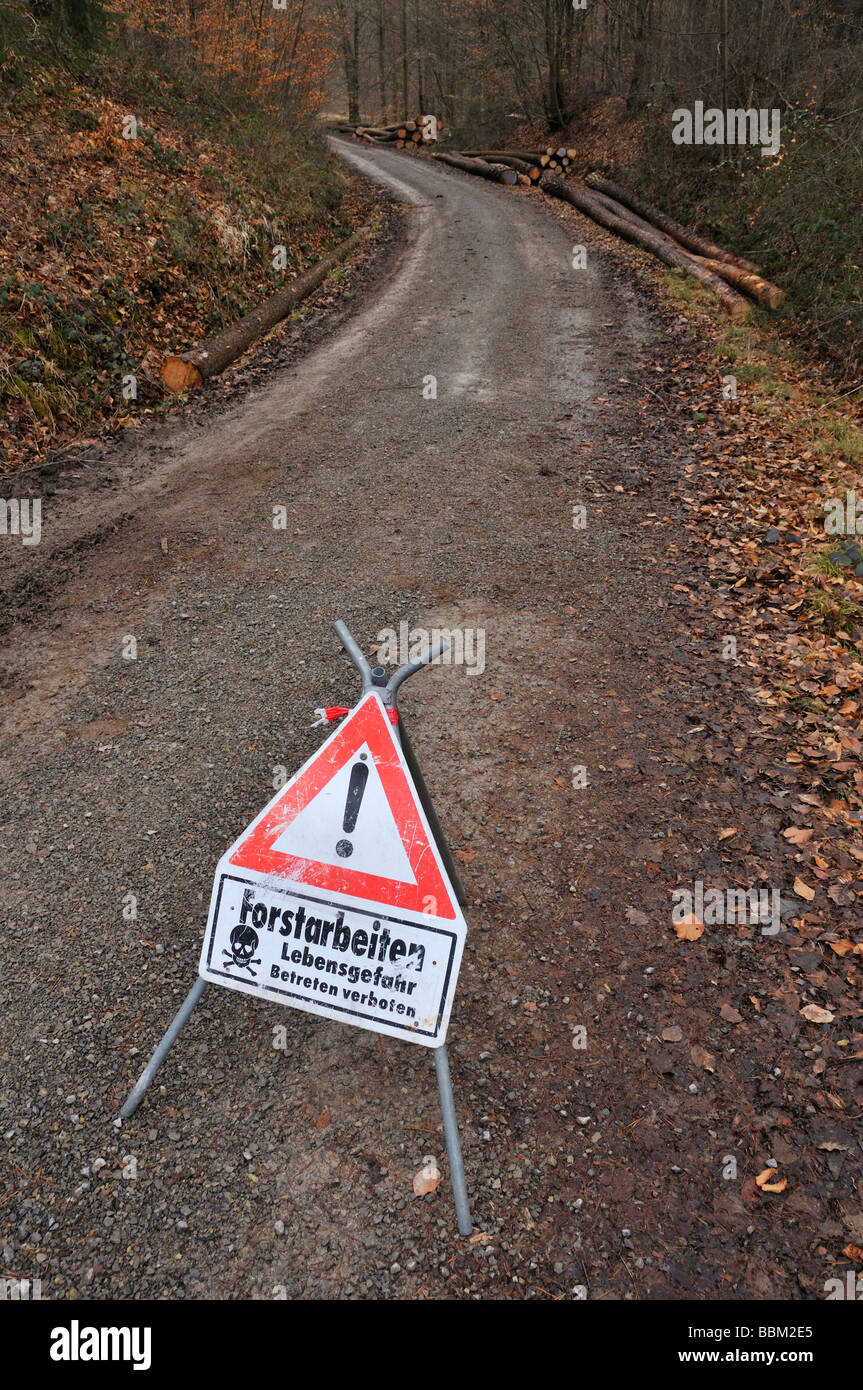 Danger sign at a forest road with inscription Forstarbeiten Lebensgefahr Betreten verboten, German for: forest work danger of l Stock Photo