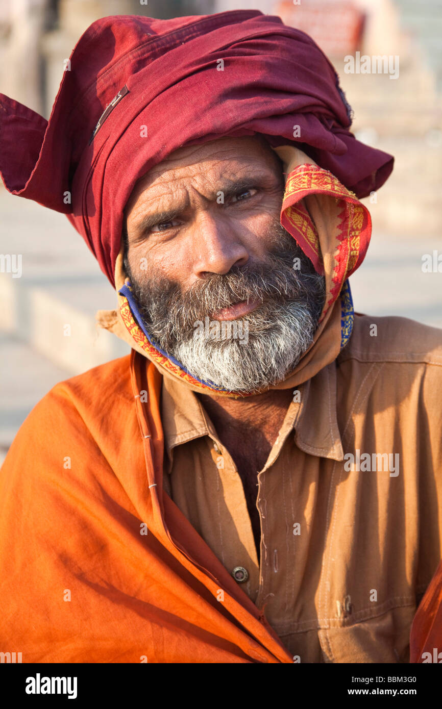 Portrait of an Indian beggar man with black beard and red turban, Varanasi, India Stock Photo