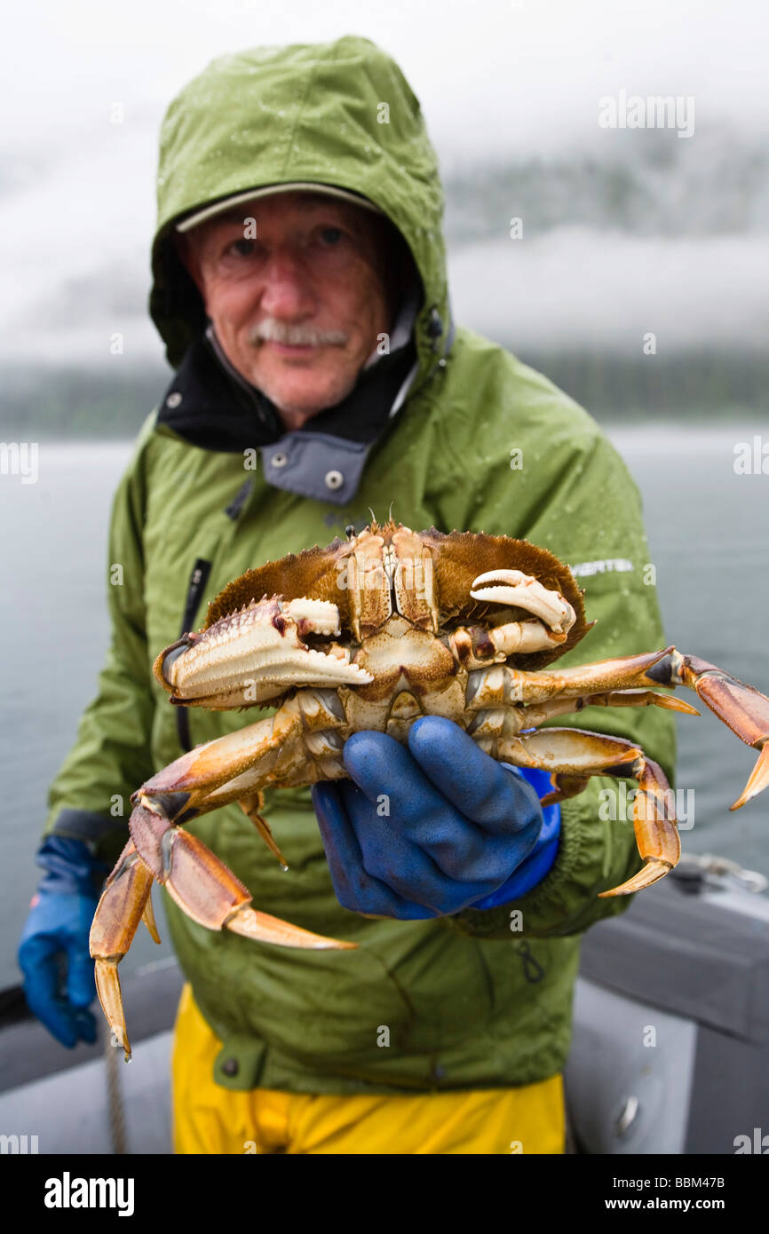 Man showing crab on board a tourist boat, Inside Passage, Southeast Alaska, USA, North America Stock Photo
