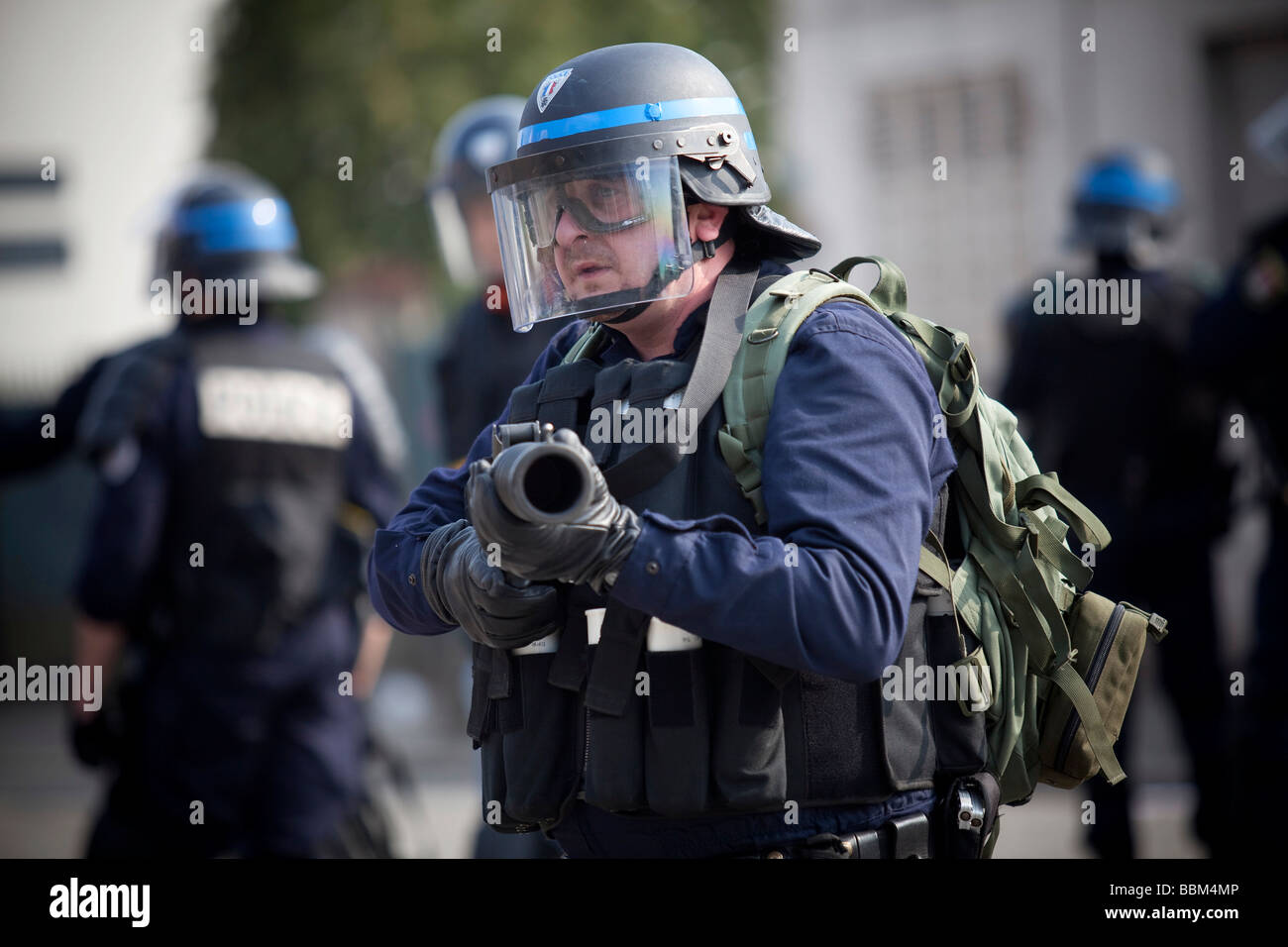 Police officer aiming with a launcher for teargas granades during ...