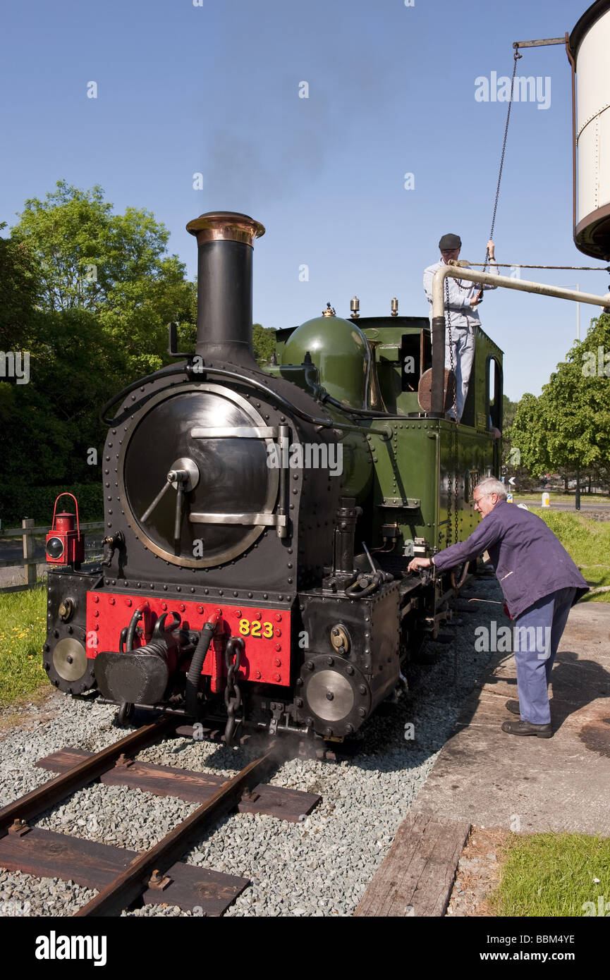Train driver and engineer refill water and lubricate steam engine with
