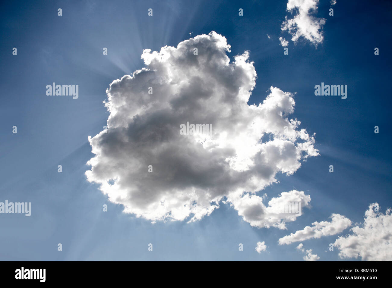 Sun behind a white cloud in front of a blue sky Stock Photo