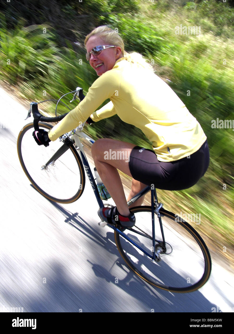 Female Cyclist riding racing bicycle. Stock Photo