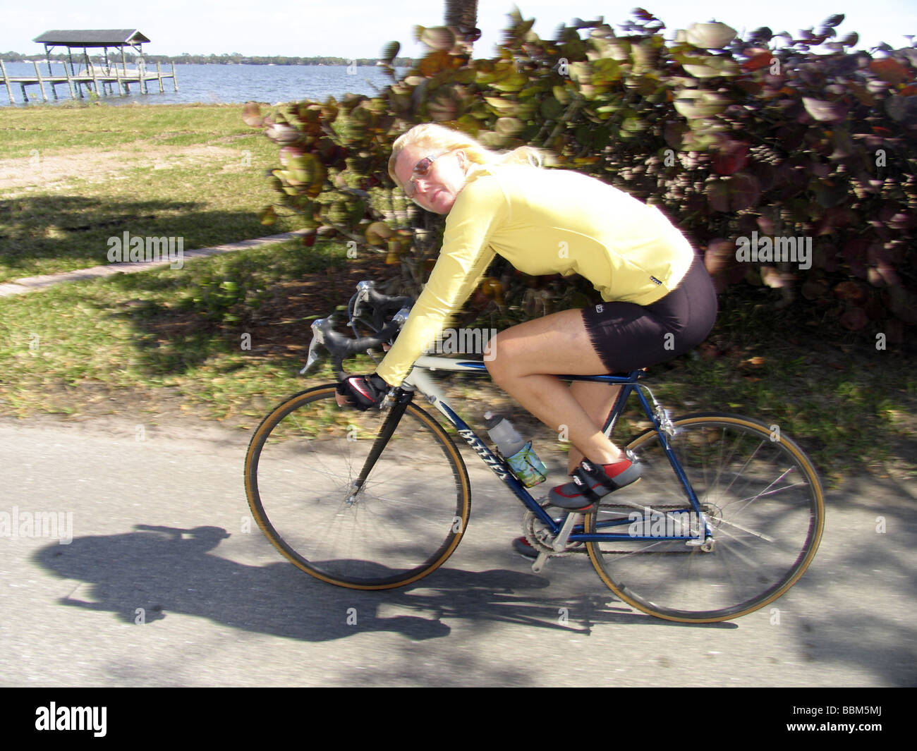 Female Cyclist riding racing bicycle. Stock Photo