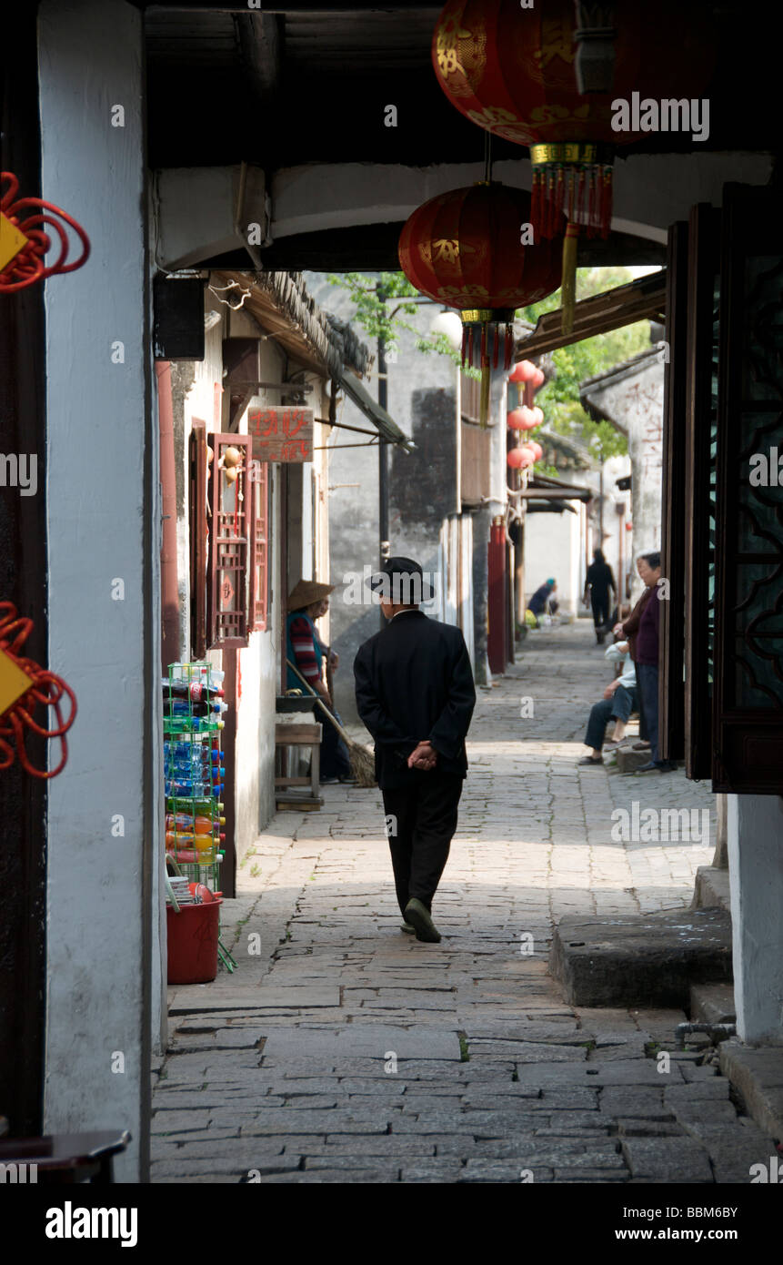 Man in old narrow dark lane of the ancient water town Zhouzhuang Jiangsu China Stock Photo