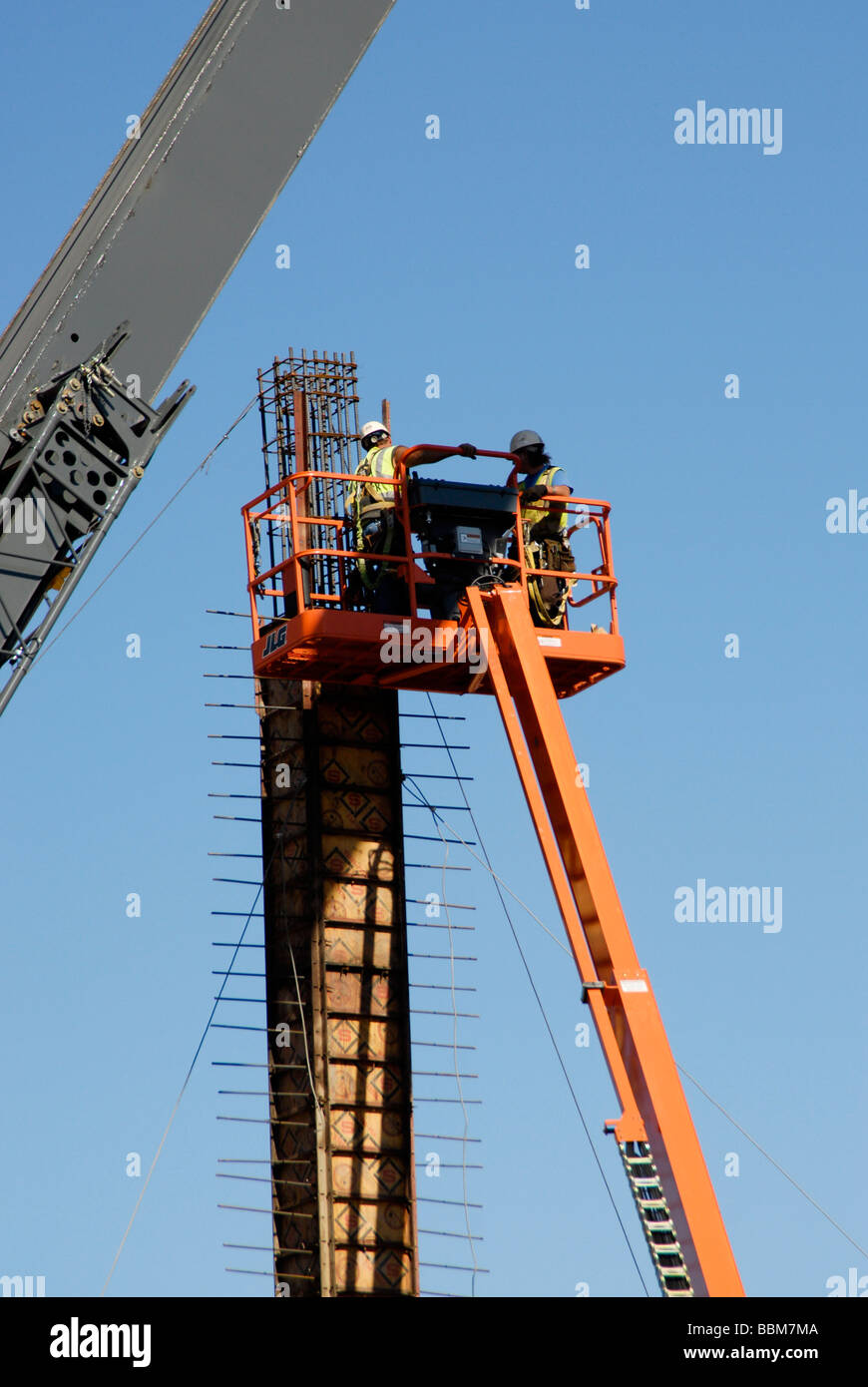 workers assembling forms on a column in a construction site Stock Photo
