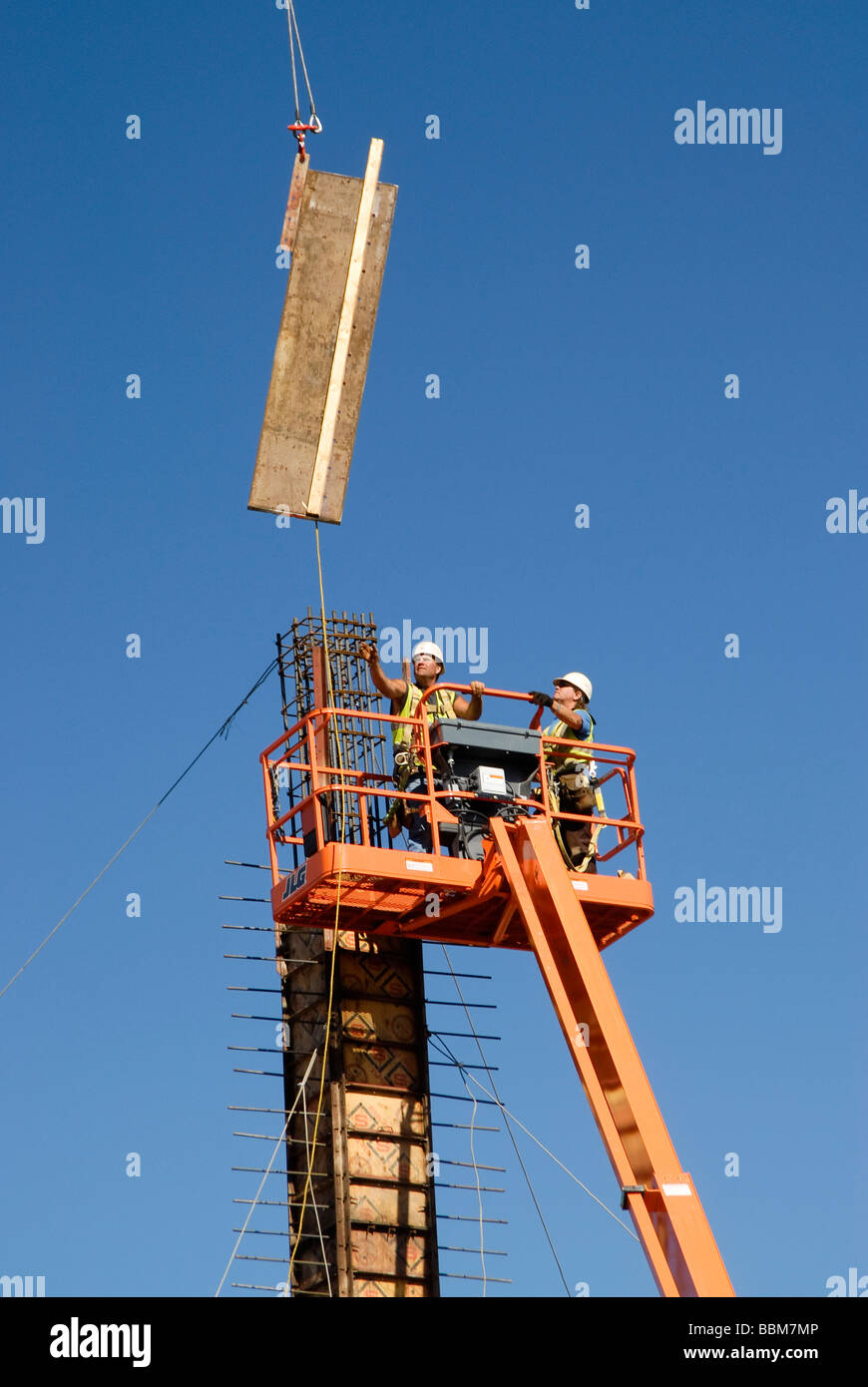 workers assembling forms on a column in a construction site Stock Photo