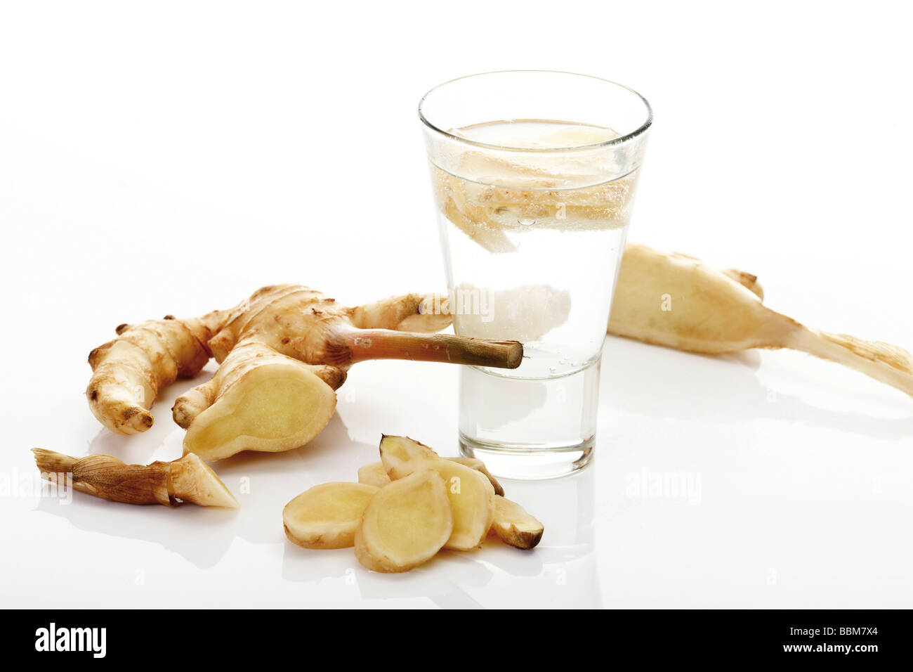Hawaiian Ingwer (Zingiber offincinale), glass of mineral water and slices of ginger Stock Photo