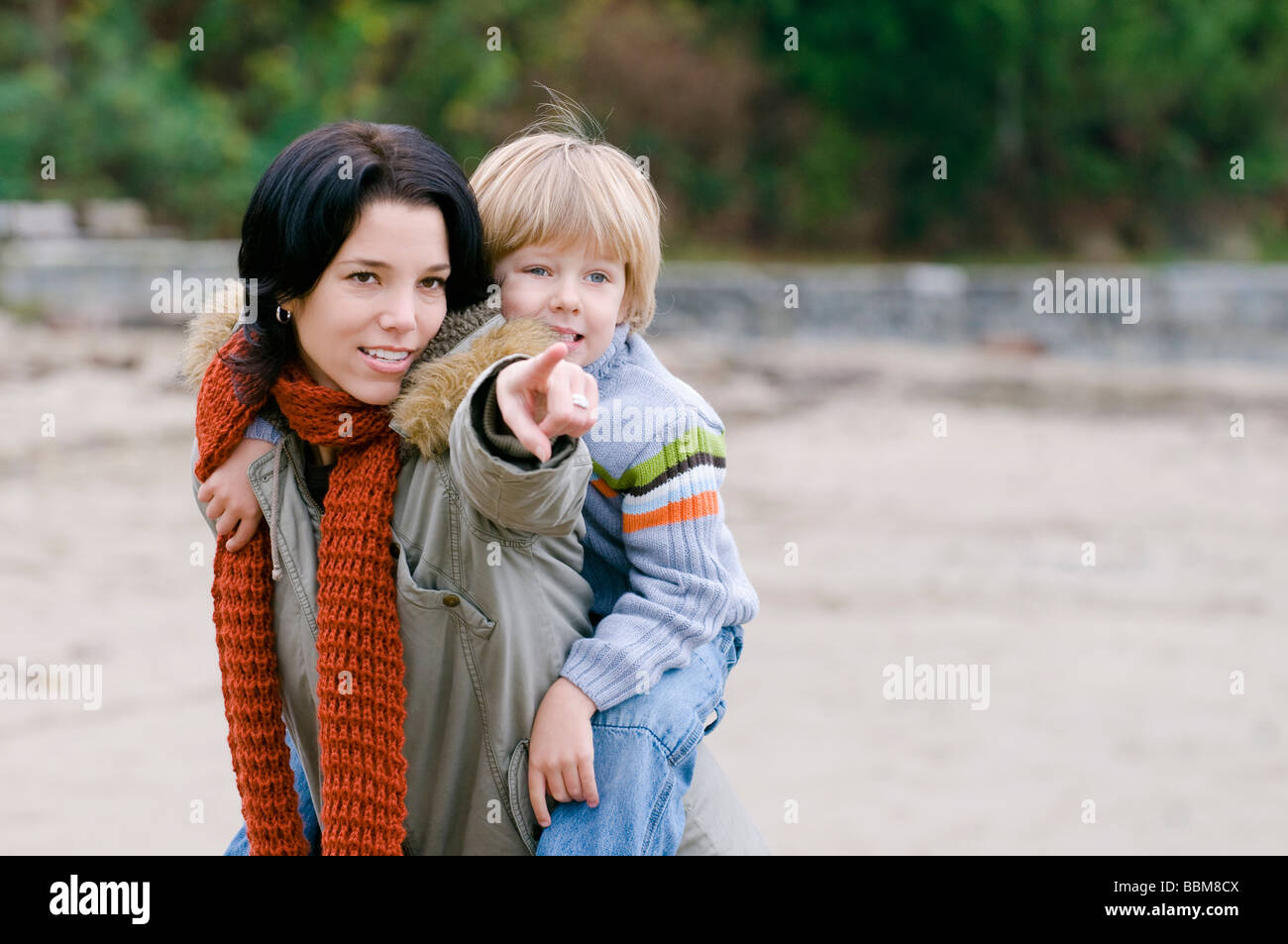 Son looks as mom points out something on the beach, Vancouver, British Columbia Stock Photo