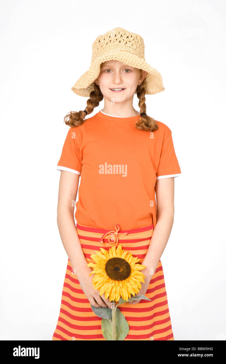 Red-haired girl with braids wearing a straw hat and holding a sunflower Stock Photo