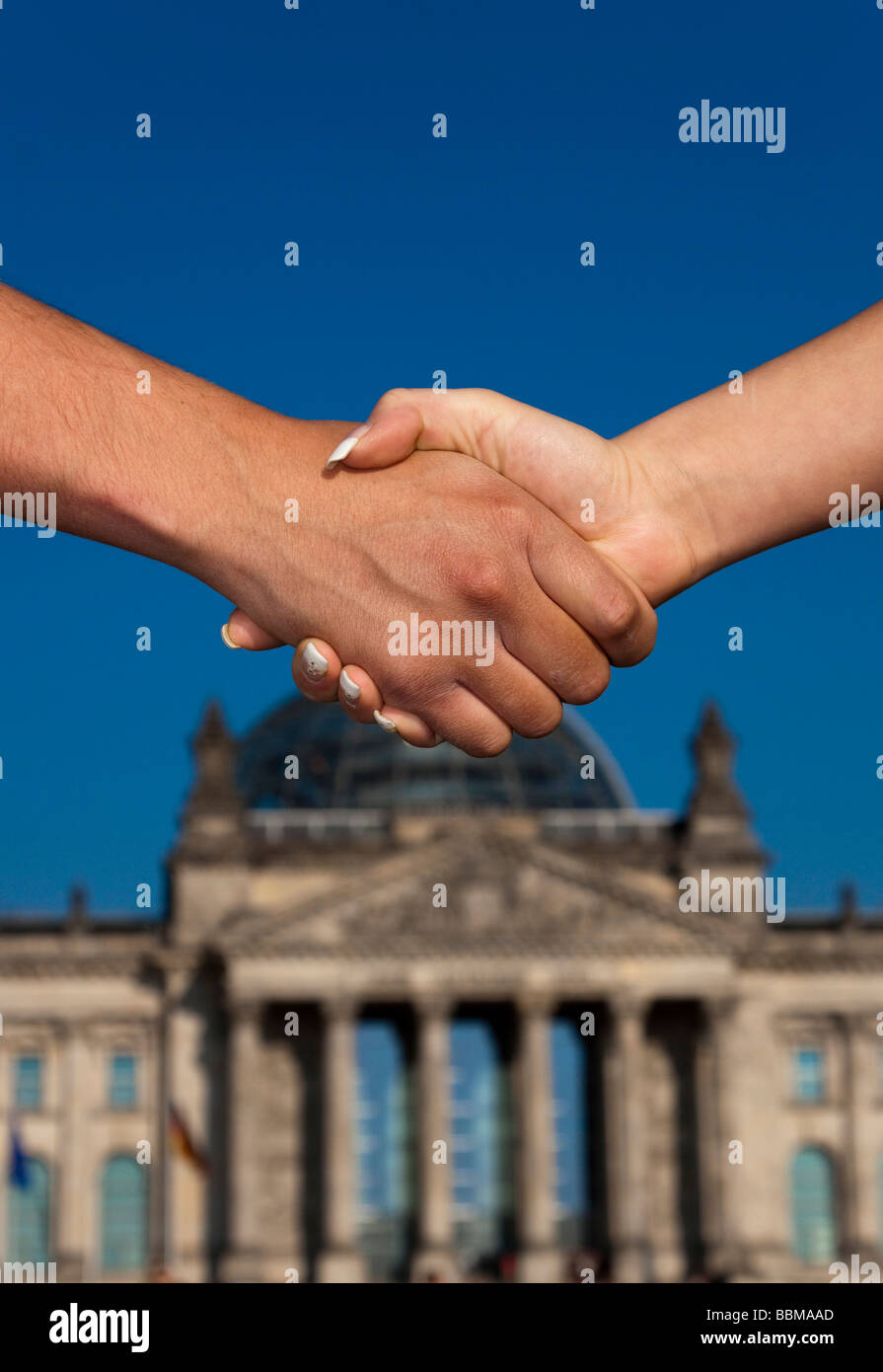 Handshake in front of the Reichstag building, Berlin, Germany, Europe Stock Photo