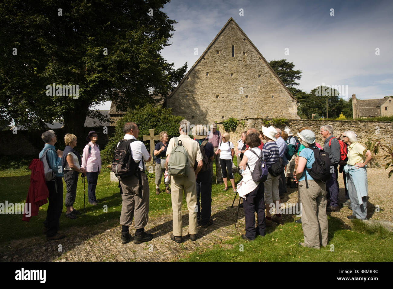 A group of retirees looking at an historic church in the Cotswolds, Eastleach Turville, Gloucestershire, UK Stock Photo