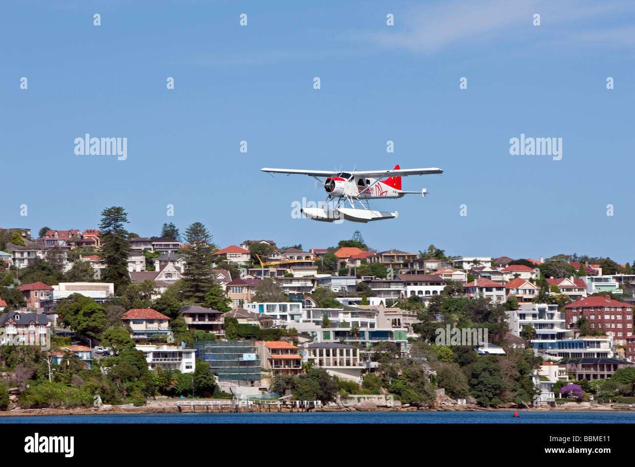 Australia New South Wales. A light amphibian with floats flying low over Sydney Harbour. Stock Photo