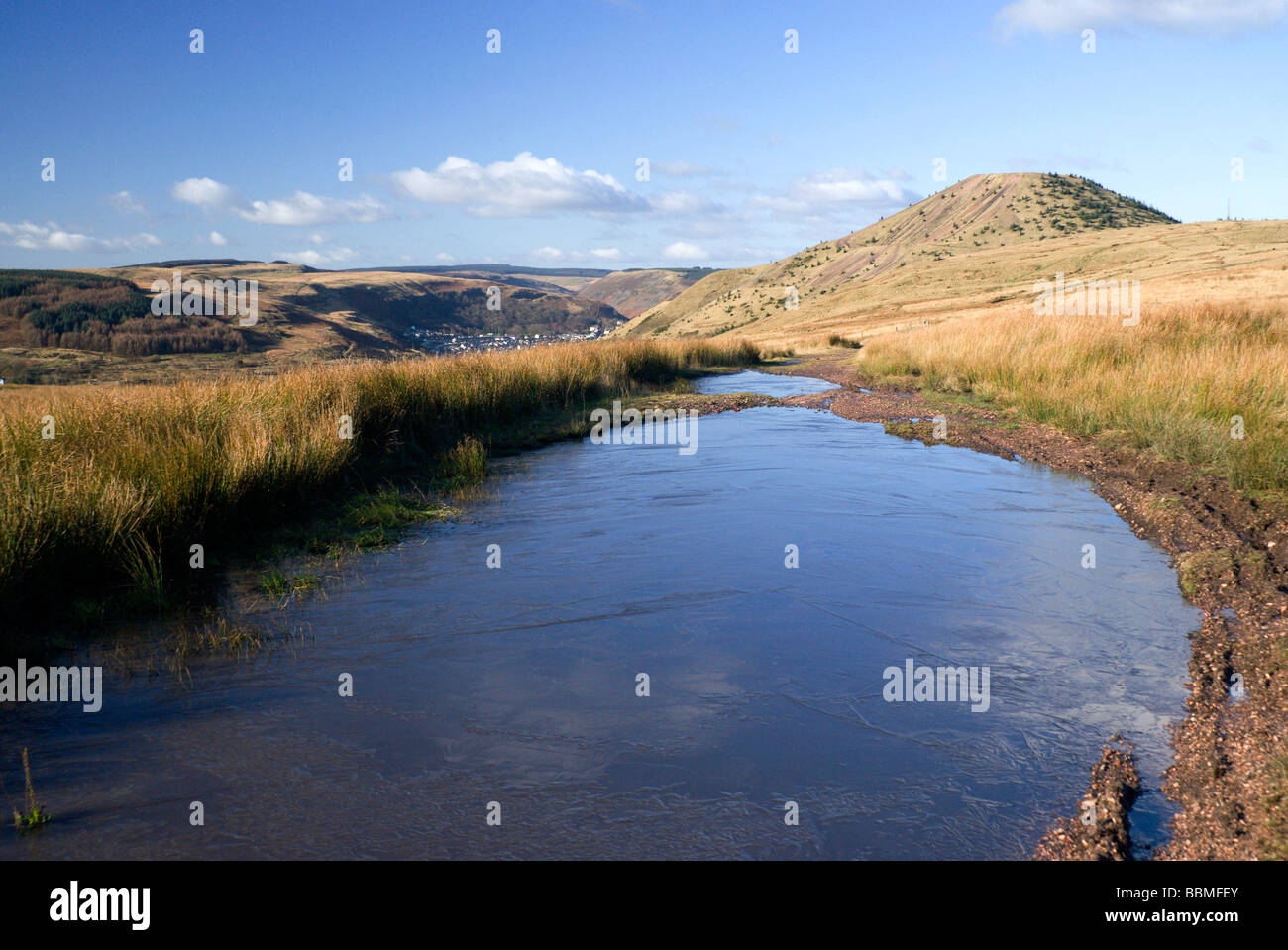 frozen puddle and view across the rhondda fach valley from hillside