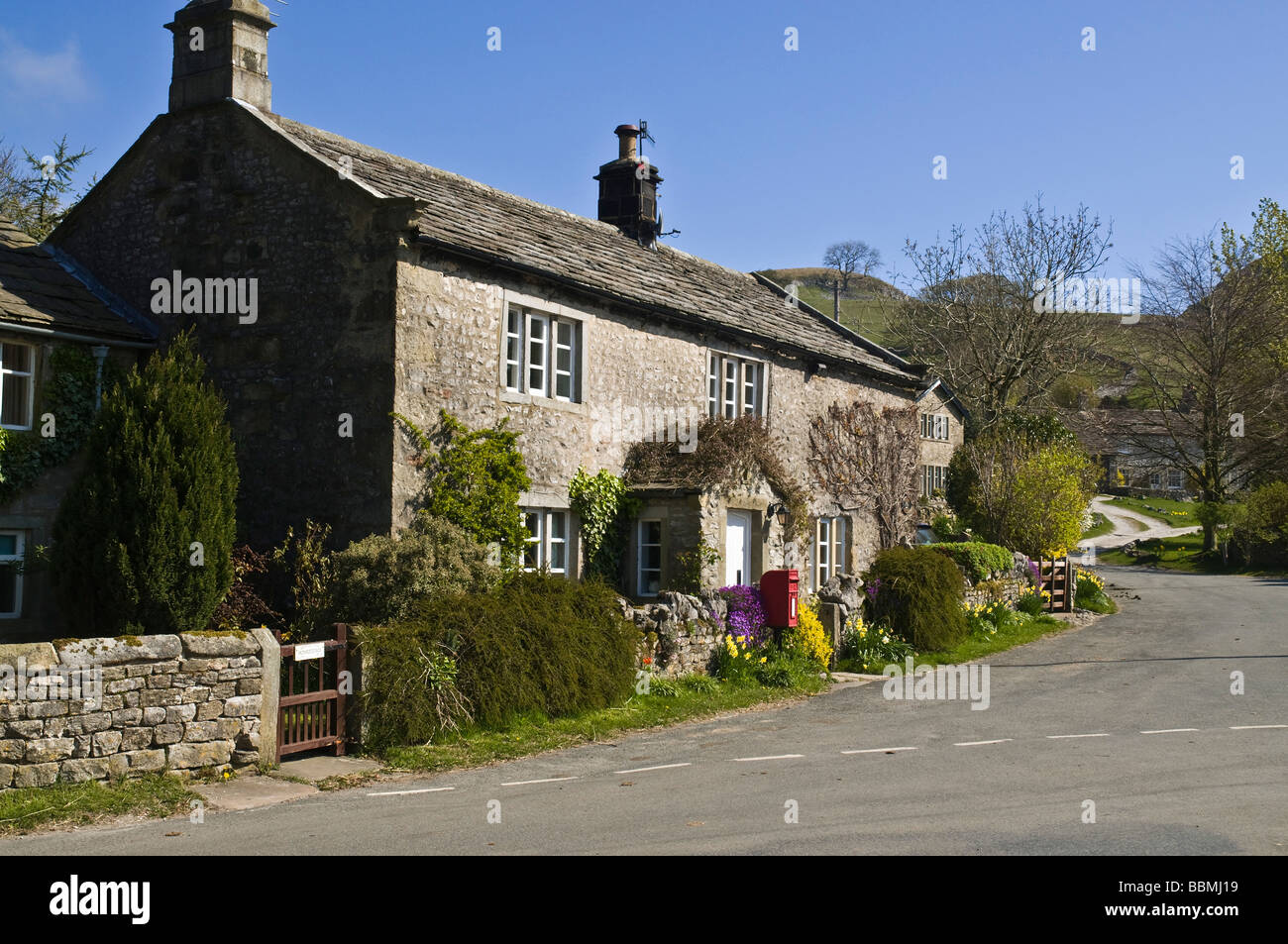 dh Yorkshire Dales National Park CONISTONE NORTH YORKSHIRE Red post box outside village cottage villages uk house Stock Photo