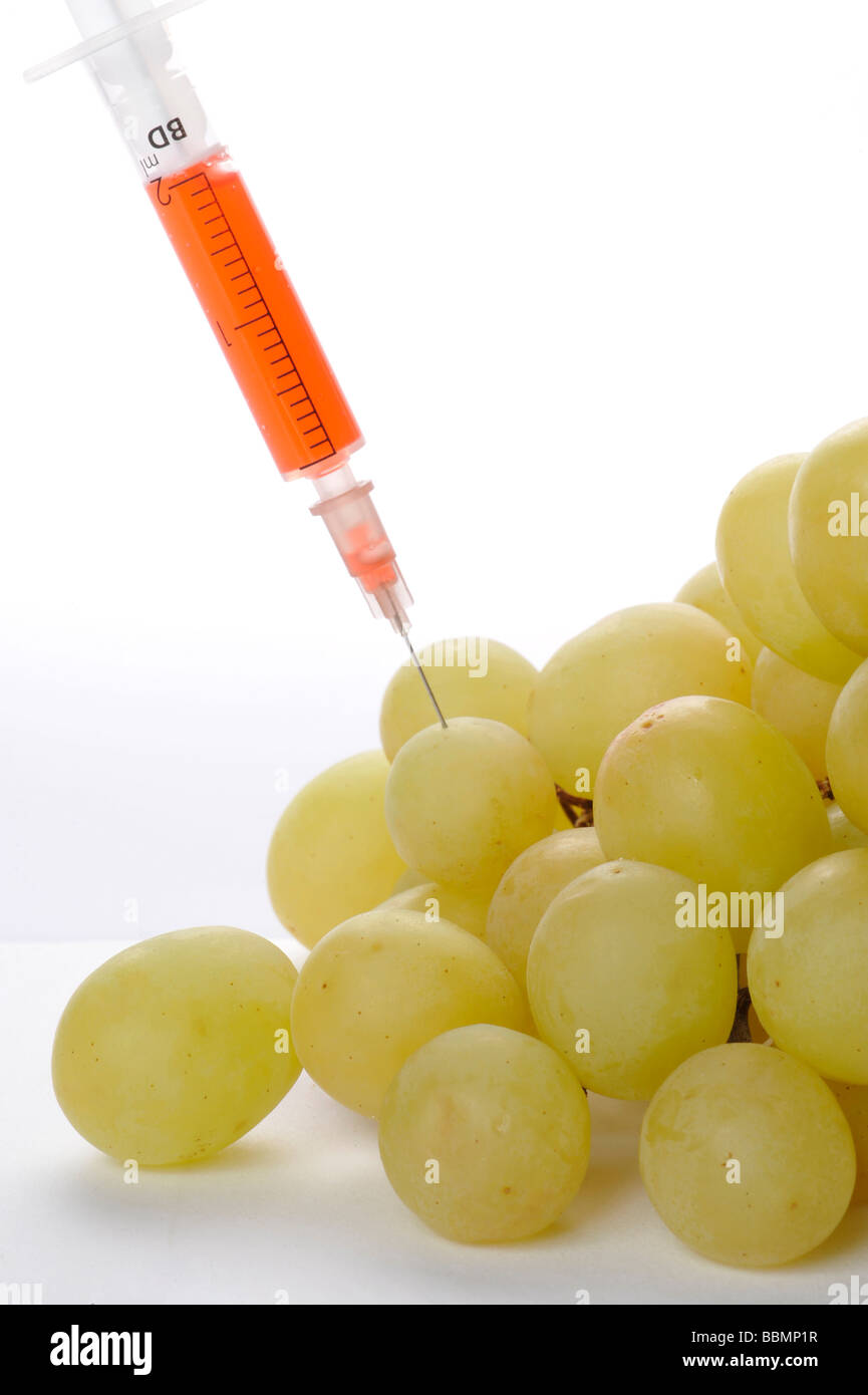 Syringe in grapes, symbolic picture, genetically modified foods Stock Photo