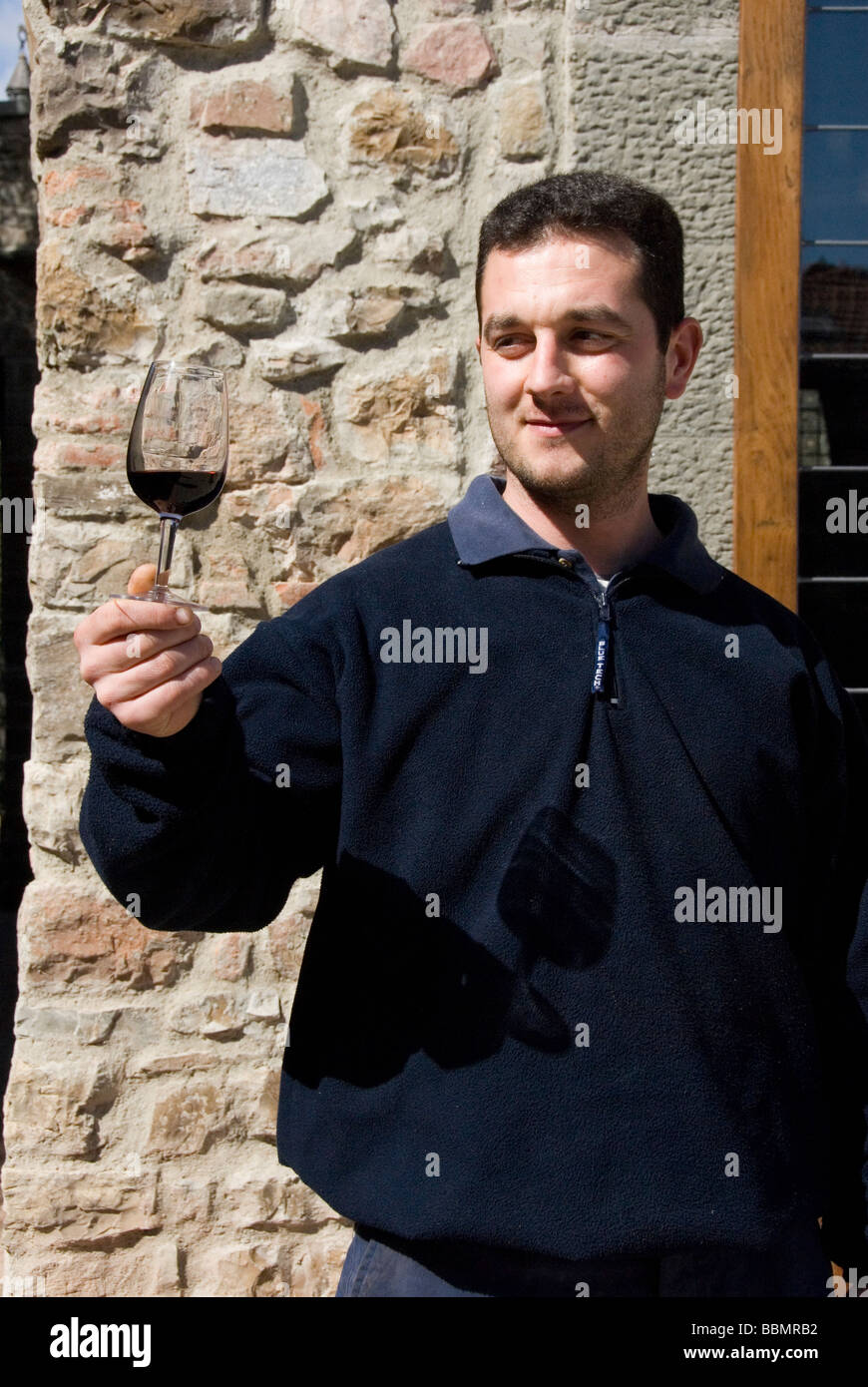 A wine maker checks the colour of the wine in a glass of Chianti Classico at the winery Quercetto in Chianti Tuscany Italy Stock Photo