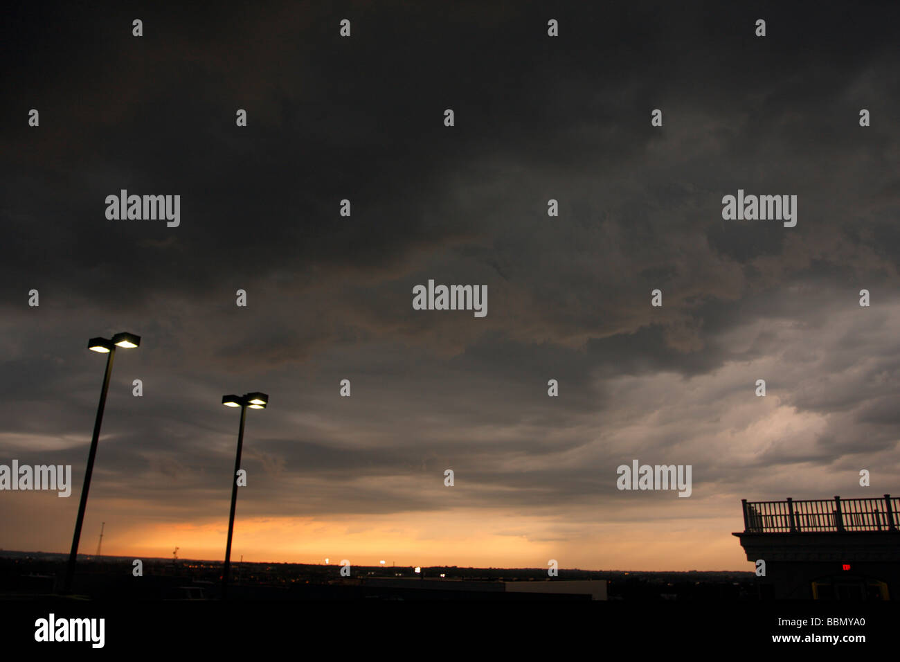 Turbulent thunderstorm skies with lit lighted streetlamps. Stock Photo