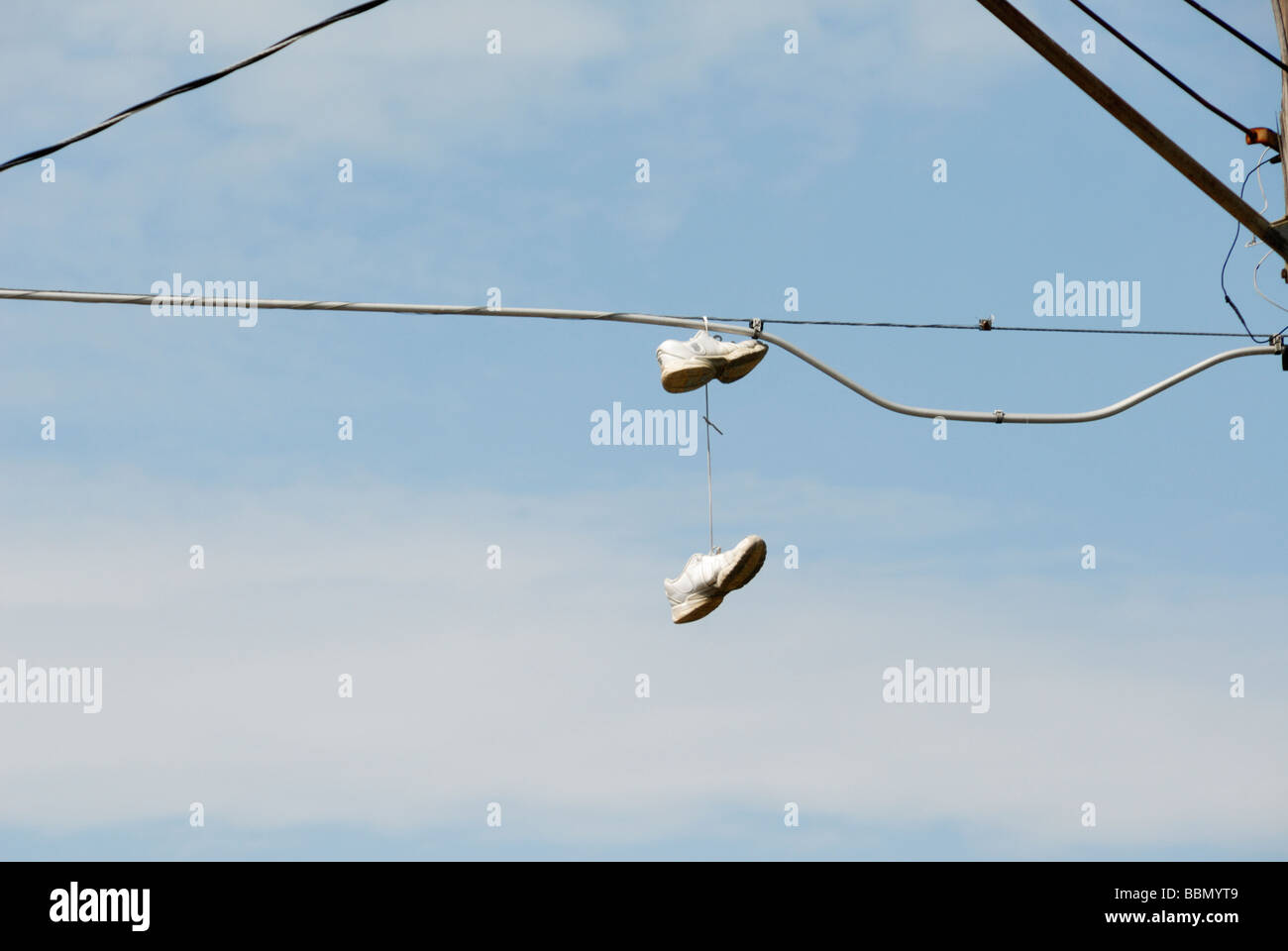 pair of tennis shoes hanging on a telephone wire Stock Photo