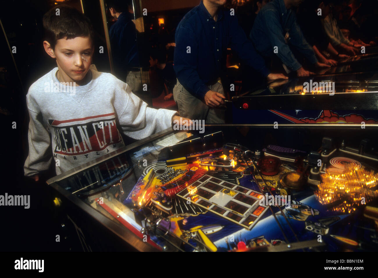 A eleven year old boy plays a pinball machine in an arcade in New York on February 5 1994 Richard B Levine Stock Photo