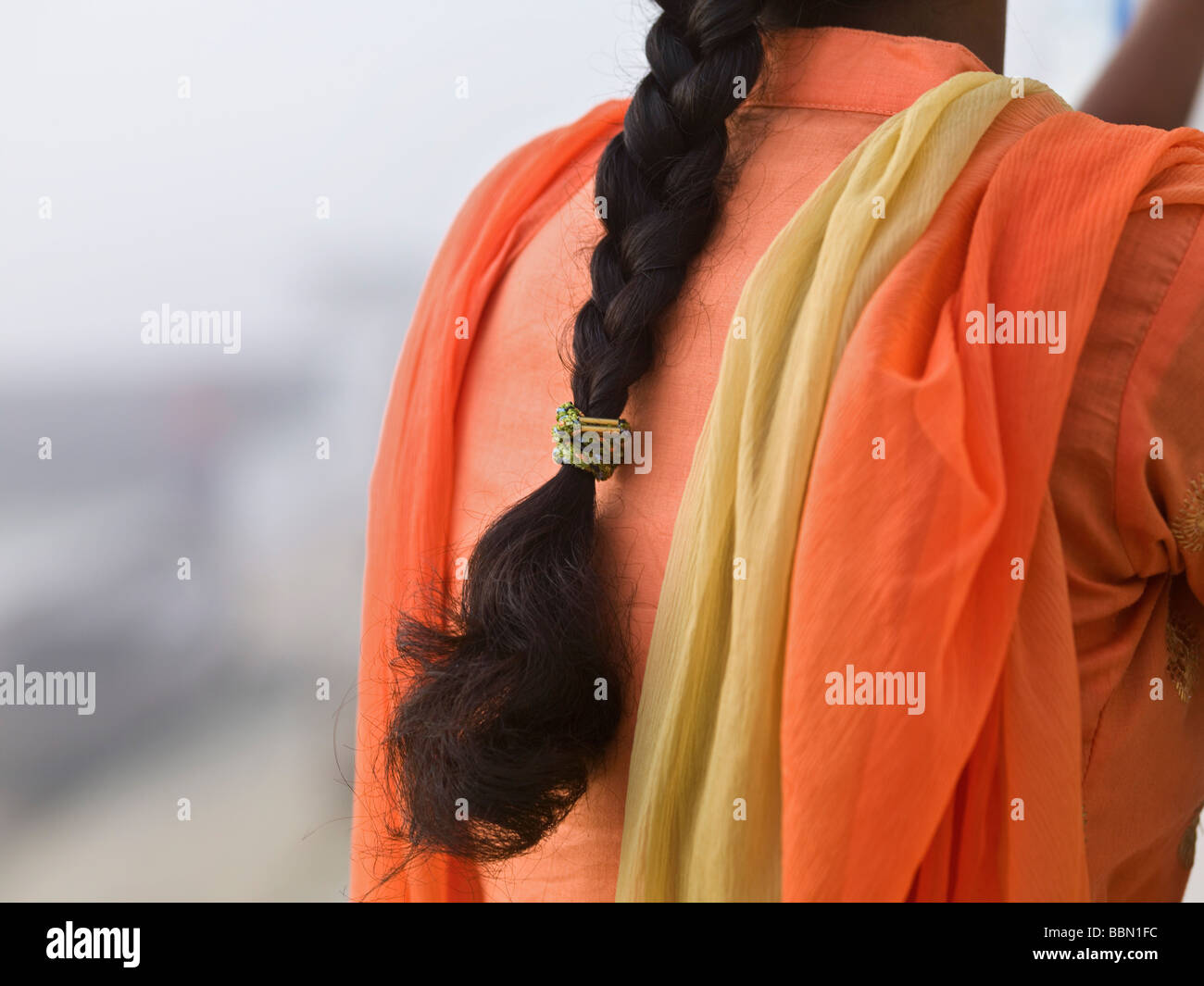 Varanasi,India;Rear view of an Indian woman wearing a vibrant orange sari Stock Photo