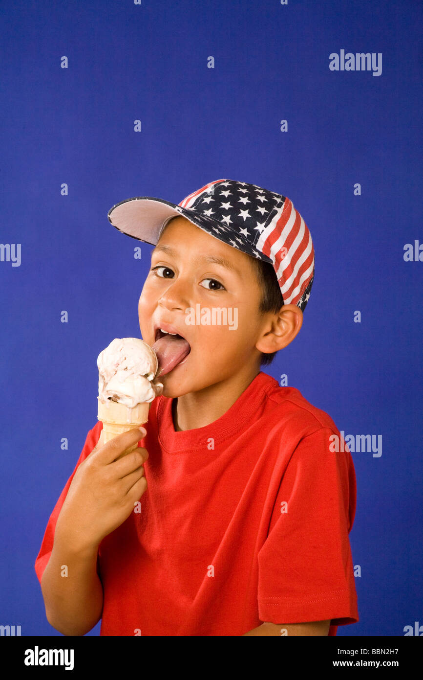 Portrait of young ethnic Hispanic boy wearing stars and stripes hat licking ice cream cone July 4th USA United States  cut out MR  © Myrleen Pearson Stock Photo