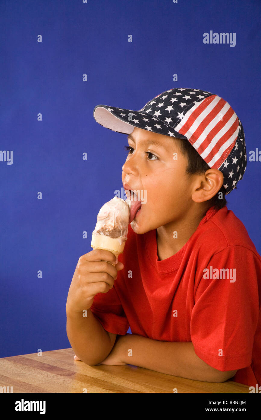 Portrait of young Hispanic boy 7-9 year old wearing stars and stripes hat licking ice cream cone, July 4th celebration cut out MR  © Myrleen Pearson Stock Photo