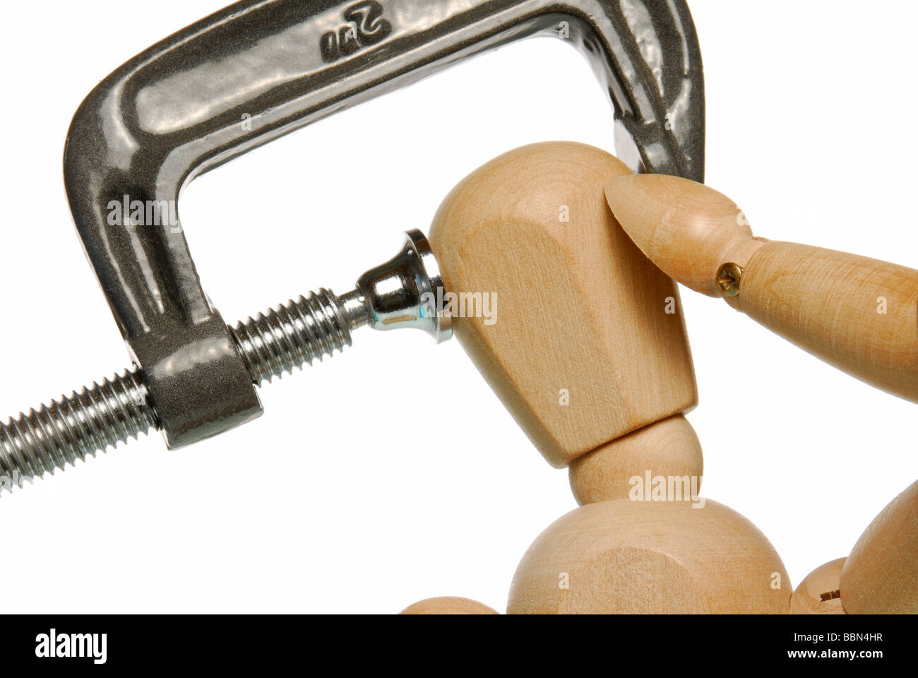 Wooden figure clamped in a vice, symbolic picture for headaches. Stock Photo