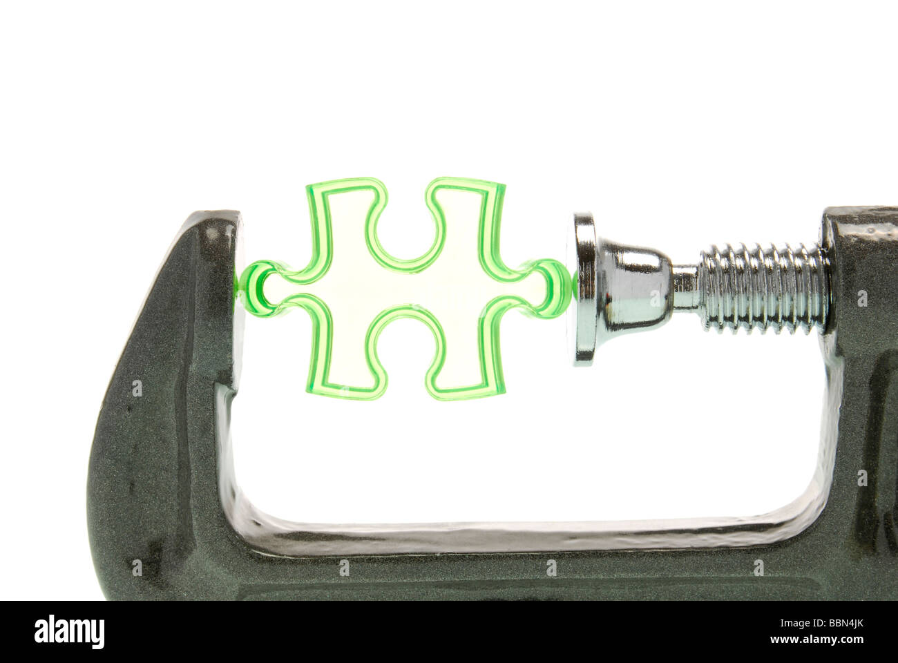 Puzzle piececlamped in a vice, a symbolic picture image for pressure to perform Stock Photo