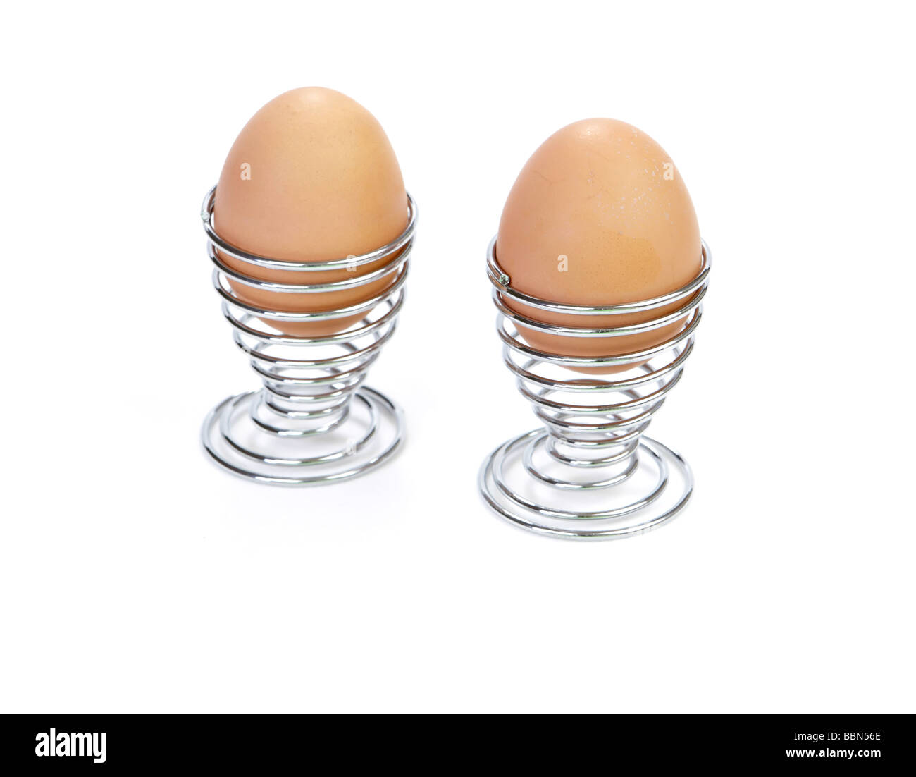 Two cooked eggs in spiral wire cups Stock Photo