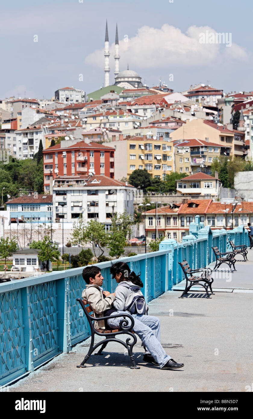 Young Turkish couple on a bench, panorama of Suetluece Mosque, Golden Horn, Istanbul, Turkey Stock Photo