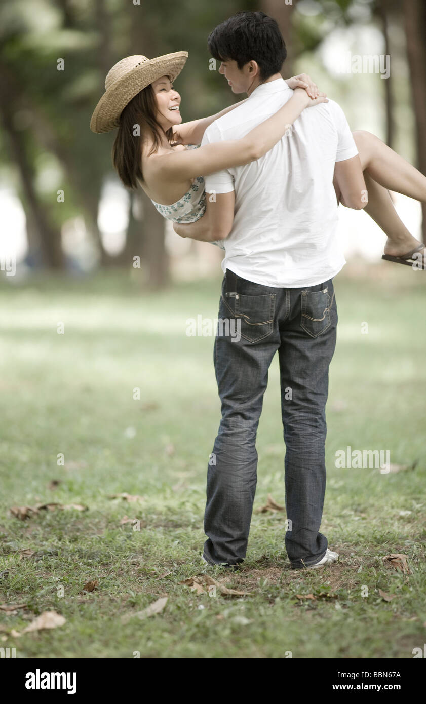 Man carrying woman in park Stock Photo